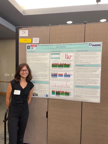 student displaying research poster
