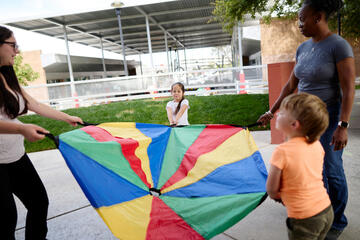 children playing with a colorful "umbrella" shoot