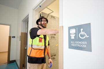 Branden Brumble tests lights for gender neutral bathroom