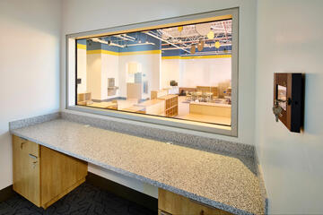 A two-way mirror looking into a preschool classroom.