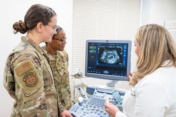 Dr. Leanne Free and military residents looking at an ultrasound screen.