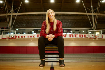 woman seated in folding chair on basketball court