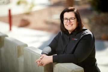 woman posing outdoors by a wall