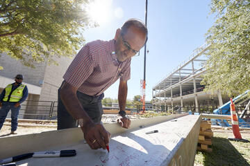 man signing construction beam