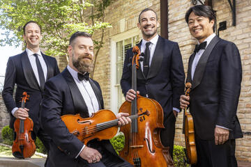 group of four male musicians in suits with stringed instruments