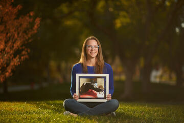 woman holding a framed photo of her pet Great Dane