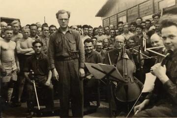 black and white photo taken outside of a group of men in an orchestra