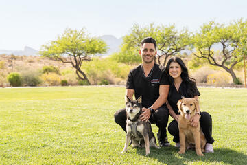 Kirk Kerkorian School of Medicine at UNLV residents Drs. Demitri and Jessica Franzoni alongside their two dogs.
