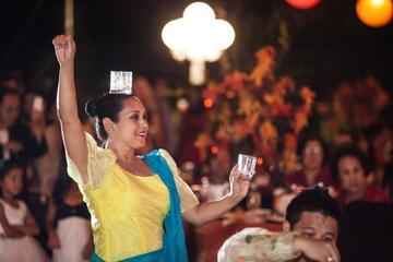 woman dancing at event with glass balanced on head