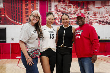 Four family members, including three women and one man, pose after a UNLV volleyball match