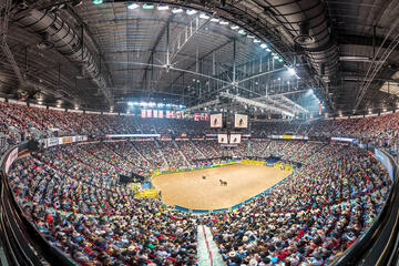 panoramic shot of arena filled with spectators watching rodeo