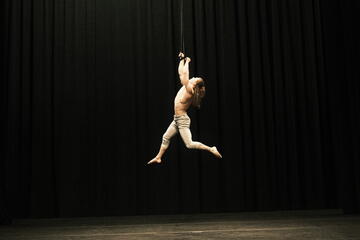 acrobat hanging from ceiling