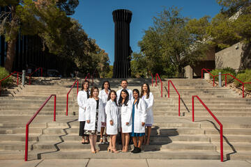 dental students in white cloats stand in front of UNLV Flashlight
