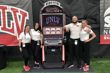 Brad Solomon stands second from right next to a UNLV slot machine