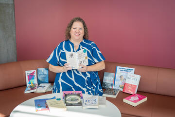 Katie Houk sitting with the medical humanities collection placed around her.