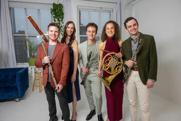 Five people holding instruments consists of flute, oboe, clarinet, French horn, and bassoon