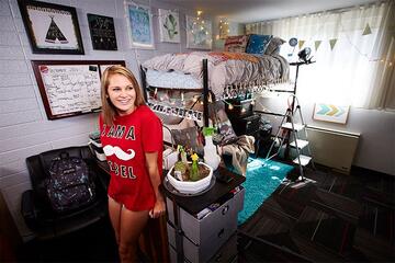 Female student shown in her dorm room.