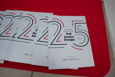 Several Senior Design program booklets sit on a table with red tablecloth