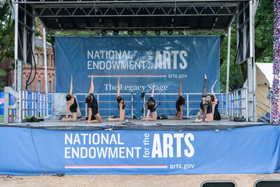 photo of dancers on a stage. Stage sign says: National Endowment for the Arts