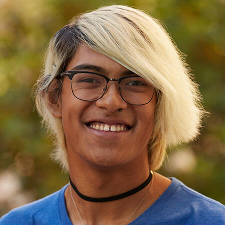 A man with glasses smiling