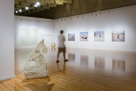 Single visitor looking at the Tested Ground museum exhibit