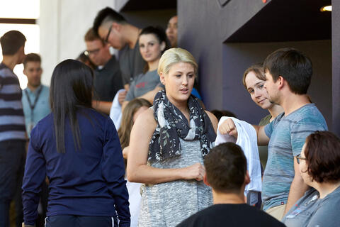 A woman speaks with her classmates
