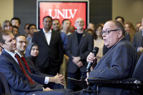 man with microphone speaking to crowd