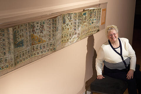 Mannetta Braunstein standing by an ancient document