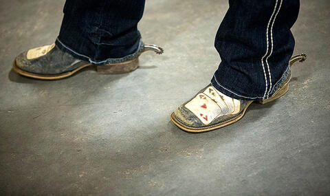 A close up photo of cowboy boots and spurs.