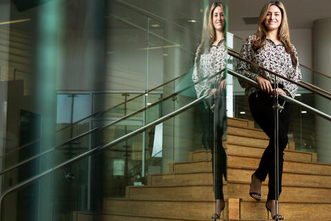 A woman is reflected in glass