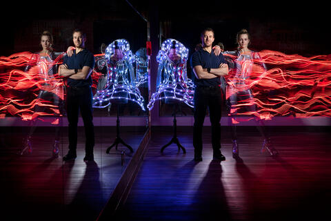 man surrounded by lit up costumes