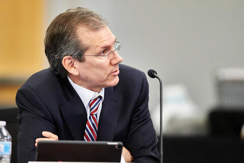 A man sits behind a microphone