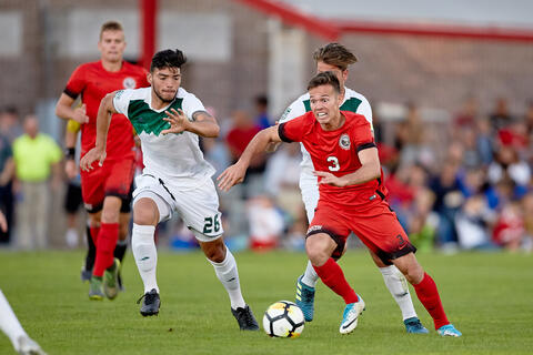 Danny Musovski dribbles a soccer ball