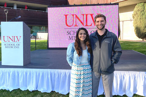 A young couple stands in front of a stage