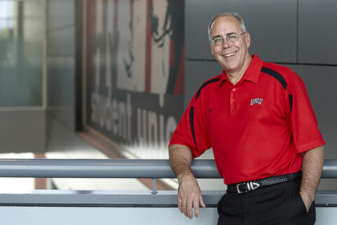 Dr. Neal Smatresk leaning against a pole rail