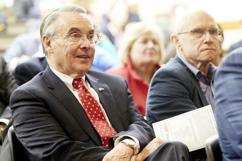 man seated at event listening