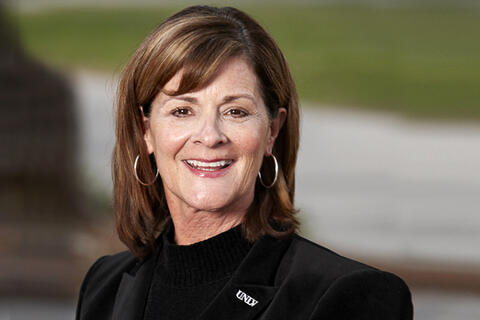 A woman in a black blouse smiling.
