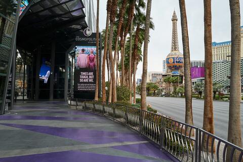 View of empty Vegas Strip walkway with sign that says: Times are tough, but so are we.