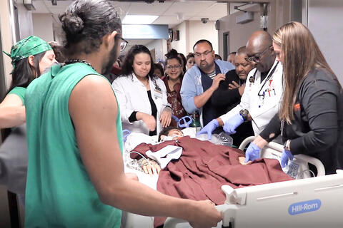 group of medical personnel surrounding a patient in hospital bed