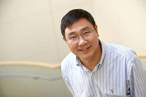 A man wearing a dress shirt and glasses.