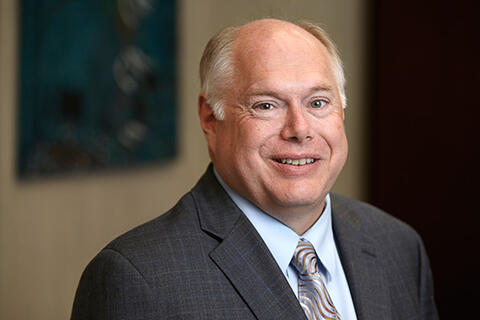 A man in a suit smiling.