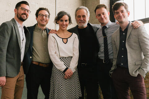Sérgio and Clarice Assad, surrounded by members of Third Coast Percussion, look towards the camera in this promotional photo.