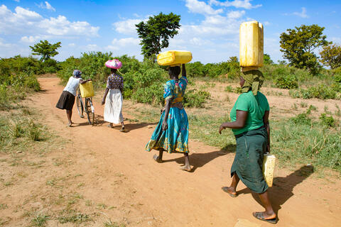 women in africa carrying water jugs