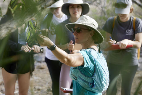 professor talking to students in the field
