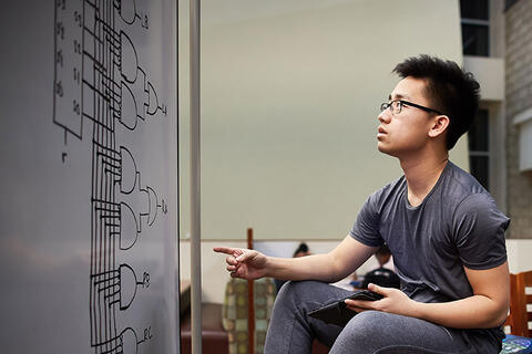 An engineering major reviewing a complex circuit diagram.