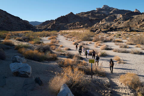 hikers in the distance along desert mountain trail