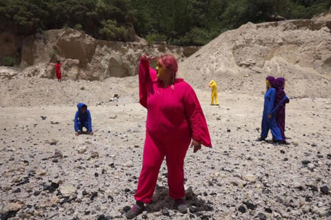 artwork of figures in colorful jumpsuits in desert