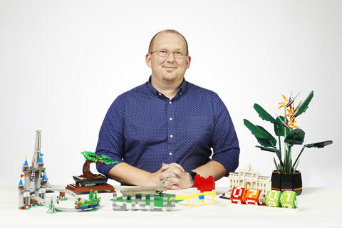 man surrounded by LEGO models