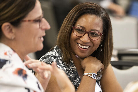 A woman smiling at another woman