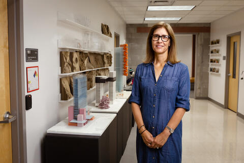 woman posing next to building models